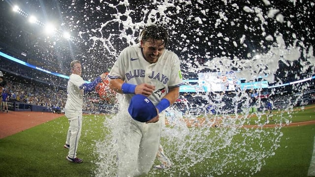 Jul 5, 2025; Toronto, Ontario, CAN; Toronto Blue Jays center fielder Myles Straw (3) throws ice water onto  right fielder Addison Barger (47) after a win over the Los Angeles Angels in the 11th inning at Rogers Centre. Mandatory Credit: John E. Sokolowski-Imagn Images