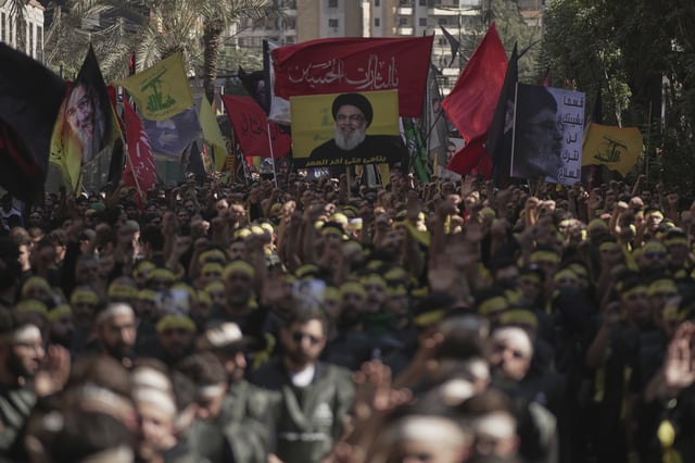 Hezbollah supporters raise their hands and beat their chests as they march during Ashoura, the Shiite Muslim commemoration marking the 7th-century death of Imam Hussein, the grandson of the Prophet Muhammad, at the Battle of Karbala, in the southern suburbs of Beirut, Lebanon, Sunday, July 6, 2025. (AP Photo/Hassan Ammar)