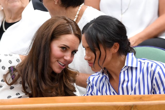 Princess Kate and Meghan Markle share a private conversation during Wimbledon Tennis Championships at the All England Lawn Tennis and Croquet Club on July 14, 2018.