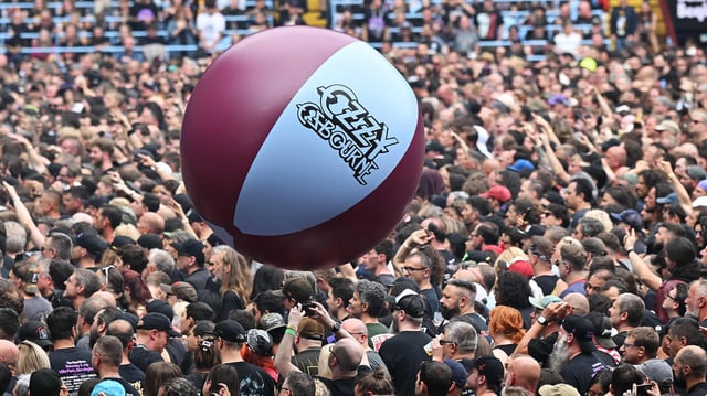 Ein großer aufgeblasener Wasserball mit der Aufschrift "Ozzy Osbourne" wandert über eine Menschenmenge.
