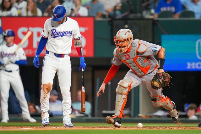 Baltimore Orioles catcher Gary Sánchez, right, chases a ball he blocked during an at bat by Texas Rangers&#39; Jonah Heim, left, in the third inning of a baseball game Tuesday, July 1, 2025, in Arlington, Texas. (AP Photo/Julio Cortez)