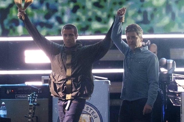 Liam y Noel Gallagher en su salida al escenario en Cardiff, Gales, para el primer concierto de Oasis en 16 años