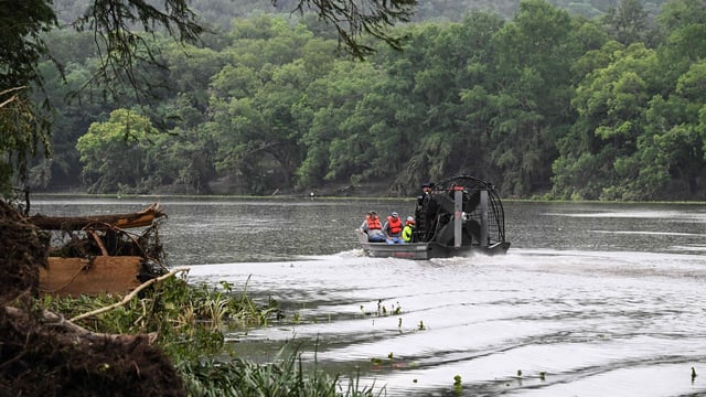 Men ride in an airboat on the Guadalupe River as they look for missing people in Hunt, Texas, on July 6, 2025, following severe flash flooding that occurred during the July 4 holiday weekend. 