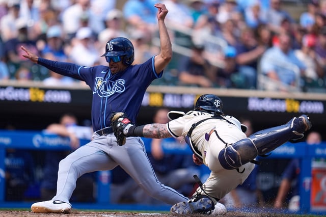 Tampa Bay Rays&#39; Christopher Morel, left, scores as Minnesota Twins catcher Christian Vázquez, right, attempts to tag him during the eighth inning of a baseball game Sunday, July 6, 2025, in Minneapolis. (AP Photo/Abbie Parr)
