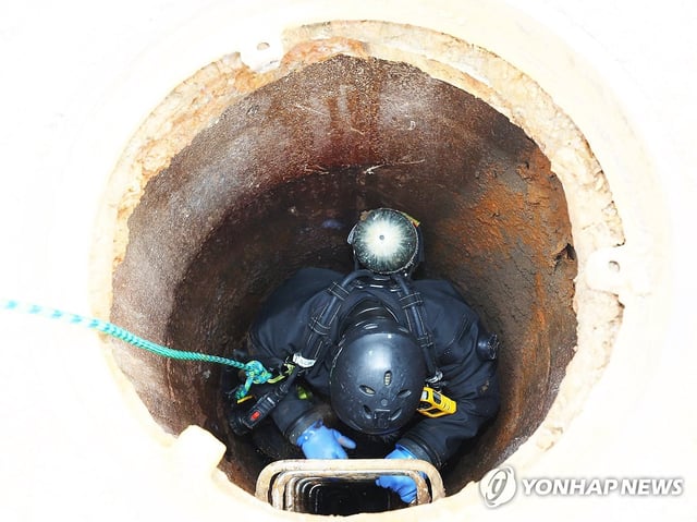 A rescue operation is under way in a manhole at a road in Incheon, west of Seoul, after one person went missing while inspecting the wastewater pipelines, while another was found in a state of cardiac arrest, on July 6, 2025. (Yonhap)