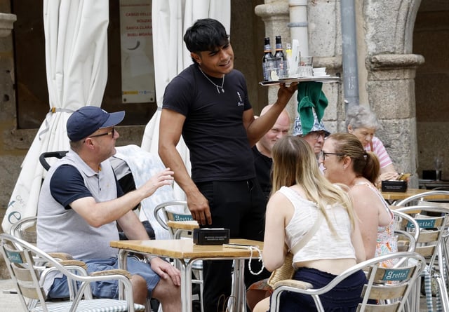 Un camarero atendiendo a varios clientes en una terraza en Vigo.