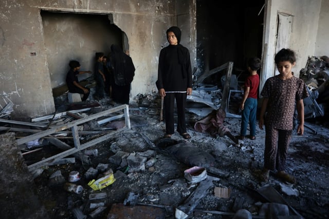 People inspect the damage after a reported Israeli strike on a clinic-turned-shelter in the  Al-Rimal neighborhood of Gaza City