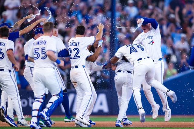 TORONTO, CANADA - JULY 5: Addison Barger #47 of the Toronto Blue Jays is swarmed by teammates as they celebrate his walk-off single to score in Myles Straw #3 of the Toronto Blue Jays in the eleventh inning of their MLB game against the Los Angeles Angels at Rogers Centre on July 5, 2025 in Toronto, Ontario, Canada.