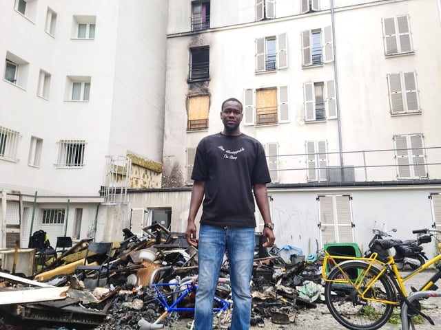 Fousseynou Cissé devant l'immeuble où l'incendie s'est déclaré, rue de la Chapelle à Paris, dimanche 6 juillet.