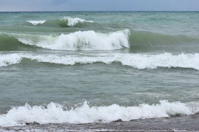 Large waves roll in at a beach along Lake Michigan.