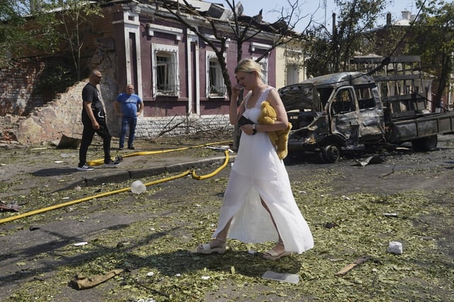 A woman reacts as she leaves her home that was destroyed by a Russian airstrike in Kharkiv, Ukraine, Monday, July 7, 2025. (AP Photo/Andrii Marienko)