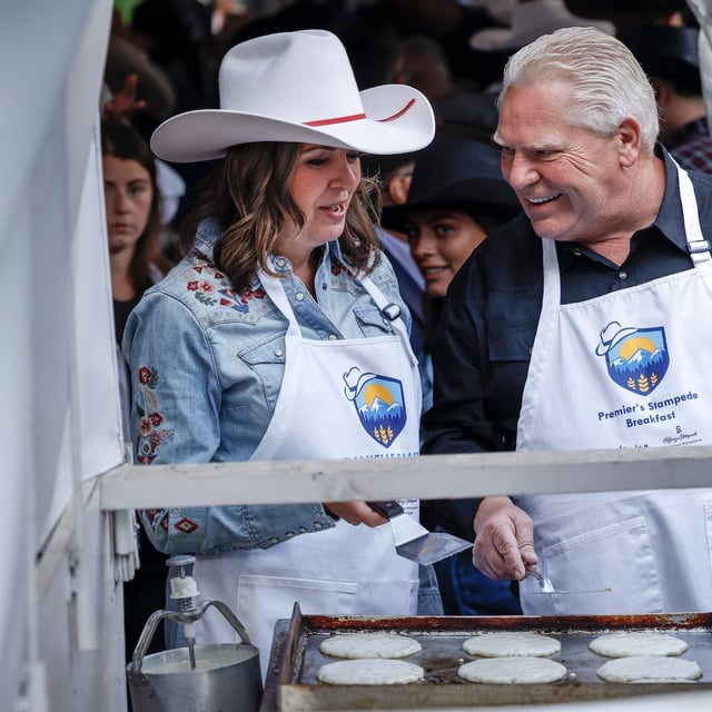 Alberta Premier Danielle Smith and Ontario Premier Doug Ford cook pancakes at the annual Stampede breakfast in Calgary Monday.
