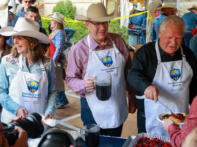 A trio of premiers, Alberta Premier Danielle Smith, Saskatchewan Premier Scott Moe and Ontario Premier Doug Ford work in the serving line at the annual Premier's Stampede Breakfast at McDougall Centre in Calgary on Monday, July 7, 2025. 