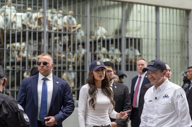Minister of Justice and Public Security Héctor Villatoro, (R), accompanies Department of Homeland Security Secretary Kristi Noem, (C), during a tour of the Terrorist Confinement Center (CECOT) on March 26, 2025, in Tecoluca, El Salvador.