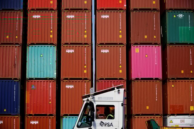 A truck driver works in front of shipping containers stacked up at Pusan Newport Terminal in Busan, South Korea, July 1, 2021. Picture taken on July 1, 2021. REUTERS/Kim Hong-Ji/File Photo