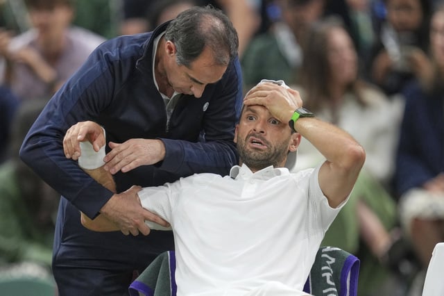Grigor Dimitrov recibe tratamiento en el pectoral derecho de parte del fisioterapeuta argentino Alejandro Resnicoff, pero ya no hay nada que hacer; el bulgaro tuvo que retirarse cuando estaba en ventaja ante Jannik Sinner en Wimbledon. (AP Photo/Kin Cheung)