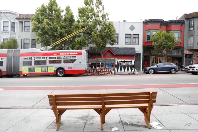 A Muni bus drives past a San Francisco Bay Area Bench Collective bench that&#39;s been planted on Mission Street. The collective has been leaving benches throughout the Bay Area, with some recent activity in San Francisco.