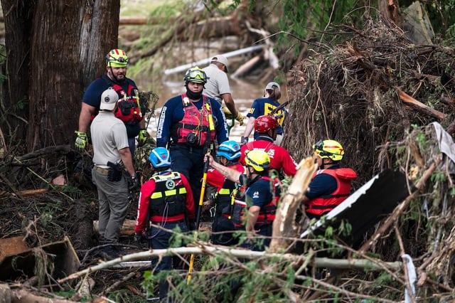 Firefighters from Ciudad Acuna, Mexico, left, aid in search and rescue efforts near the Guadalupe River days after a flash flood swept through the area, Monday, July 7, 2025, in Ingram, Texas. (AP Photo/Eli Hartman)