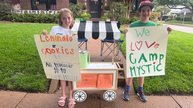 Siblings Corrigan and Cannon Camp, 9-year-old twins, pose in front of their lemonade stand in Fort Worth on Sunday, July 6. They raised more than $5,000 for Camp Mystic, an all-girls Christian camp that was devastated by flooding in Central Texas during the Fourth of July weekend. Corrigan attended Camp Mystic for two weeks in June.