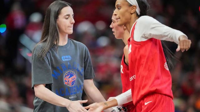 Indiana Fever guard Caitlin Clark (22) high-fives ex-teammate DeWanna Bonner (25).