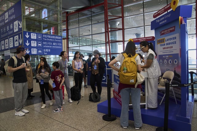 Tourists wait to take a half-day tour to the tourism destination which was offered by a travel agency Trip.com Group, at the Beijing Capital International Airport, in Beijing on June 15, 2025. (AP Photo/Andy Wong)