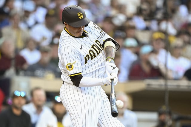 Jul 7, 2025; San Diego, California, USA; San Diego Padres third baseman Manny Machado (13) hits a single during the first inning against the Arizona Diamondbacks at Petco Park. Mandatory Credit: Denis Poroy-Imagn Images