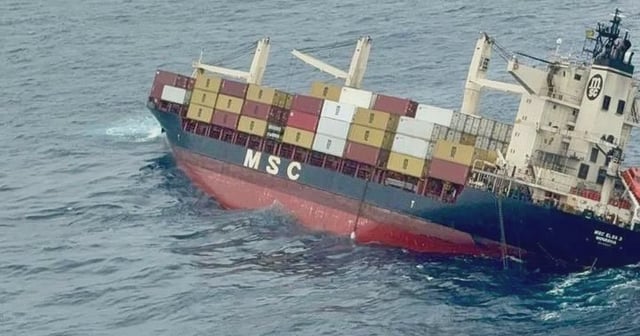 The image shows the container vessel, tilted to the right, in the sea.