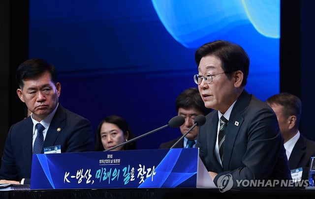 President Lee Jae Myung (R) presides over a debate session with defense industry officials in Seoul on July 8, 2025, held to commemorate the inaugural K-Defense Day. (Yonhap)