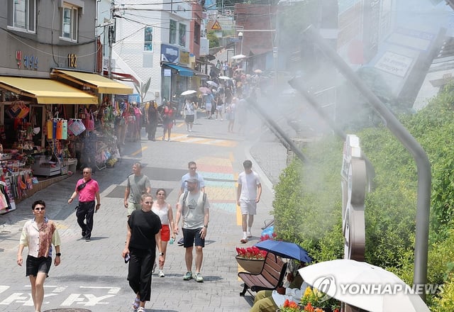 Foreign visitors cool off in sweltering weather in the southeastern port city of Busan on July 8, 2025, as most parts of the country remain under extreme heat warnings or advisories. (Yonhap)