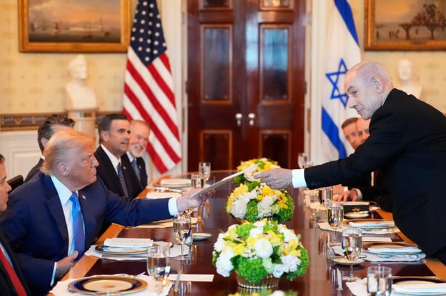 El primer ministro israelí Benjamin Netanyahu, derecha, le entrega al presidente Donald Trump una carpeta durante una reunión en el Salón Azul de la Casa Blanca, el lunes, en Washington. (AP/Alex Brandon)