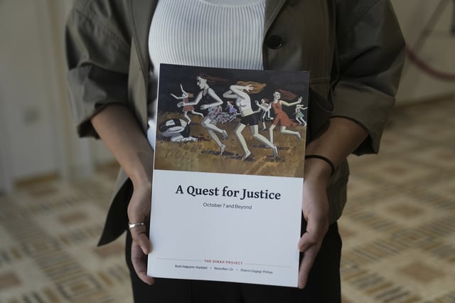 A copy of the report by the Dinah Project on sexual violence committed on Oct. 7, 2023 by Hamas is displayed by a journalist before a ceremony presenting the report to Israel's first lady Michal Herzog in Jerusalem, Tuesday, July 8, 2025. (AP Photo/Maya Alleruzzo)