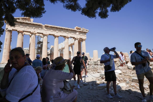 People stand in a shade while visiting the Acropolis, at the start of a 3-days heatwave with temperatures expected to overpass 40 Celsius degrees, in Athens, Greece, July 7,  2025. REUTERS/Louisa Gouliamaki