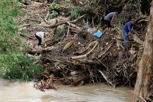 People clean up debris along the Guadalupe River in Center Point, Texas, on Monday, July 7, 2025. A flash flood that occurred on July 4 caused widespread destruction in the area.
