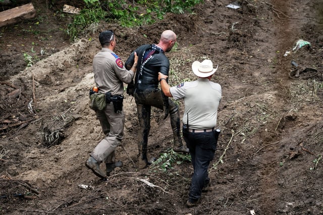 A Texas Department of Public Safety Trooper and Kerr County Sheriff&#39;s deputy assist a rescue diver out of the water at a search and rescue site along the Guadalupe River after a flash flood swept through the area, Monday, July 7, 2025, in Ingram, Texas. (AP Photo/Eli Hartman)