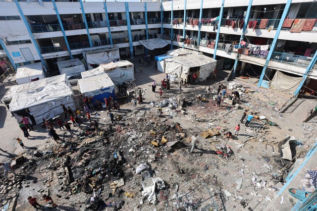 Palestinians inspect the site of an overnight Israeli strike on a school sheltering displaced people, in Bureij refugee camp, in the central Gaza Strip, July 8, 2025. REUTERS/Ramadan Abed
