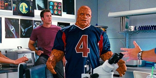 Actors Chris Evans and Michael Chiklis as Johnny Storm and Ben Grimm, standing in a lab in Fantastic Four.