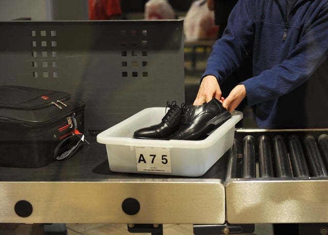 An air traveler places his shoes in a bin before passing through the Transportation Security Administration (TSA) security check at  Los Angeles International Airport (LAX) on February 20, 2014 in Los Angeles, California. The TSA recently launched a PreCheck program that allows those enrolled in a trusted traveler network to enter about 100 US airports through a special security lane where they dont have to take off shoes, belts and jackets or remove laptops, liquids or gels.  AFP PHOTO / ROBYN BECK        (Photo credit should read ROBYN BECK/AFP via Getty Images)