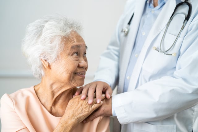 Stock image of a doctor comforting a patient with dementia.