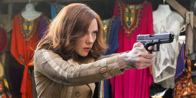Scarlett Johansson as Black Widow walks with a weapon in a Lagos street market in Captain America: Civil War