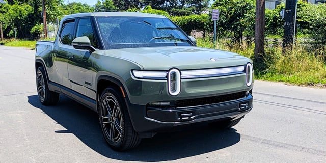 A Launch Green 2026 Rivian R1T Quad electric pickup truck is parked.