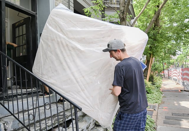 Canada's housing agency says advertised rents in major cities are easing due to factors such as increased supply and slower immigration, but renters are still not feeling relief relative to their income levels. Kyle Jerry, right, helps De-Ren Jhou carry a mattress into an apartment building on Quebec's unofficial moving day in Montreal, Tuesday, July 1, 2025. THE CANADIAN PRESS/Graham Hughes