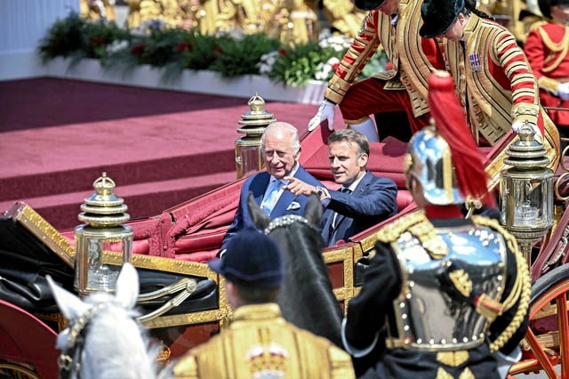 Emmanuel Macron et Charles III arrivant à Windsor à bord d'une calèche. 
