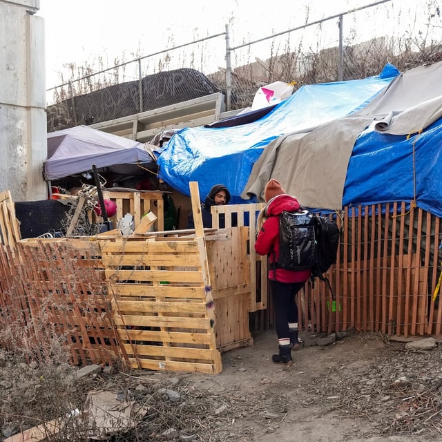 Outreach worker Lorraine Lam distributes cold weather supplies to a tented resident, as temperatures plummet in Toronto on Wednesday, Jan. 8, 2025. THE CANADIAN PRESS/Chris Young