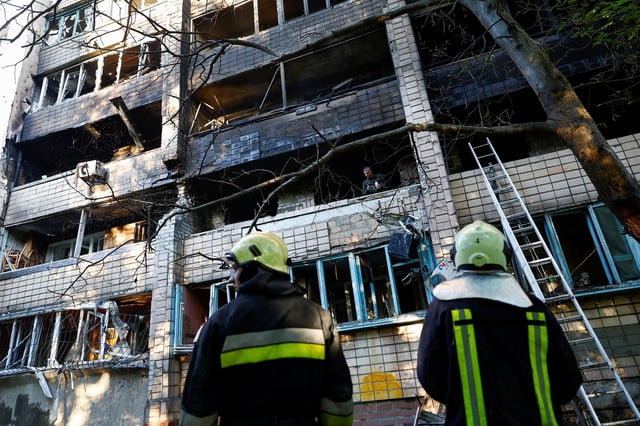 Firefighters work at an apartment building which was damaged during Russian drone and missile strikes in Kyiv on July 4.