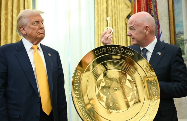 TOPSHOT - US President Donald Trump watches as FIFA president (Fédération Internationale de Football Association) Gianni Infantino presents him with the key to unlock the new FIFA Club World Cup trophy in the Oval office of the White House, in Washington, DC, on March 7, 2025. (Photo by Jim WATSON / AFP) (Photo by JIM WATSON/AFP via Getty Images)