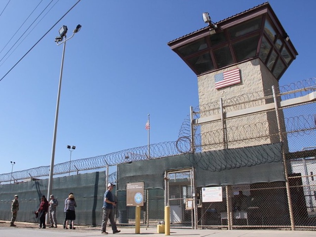 People walk past a guard tower outside the fencing of Camp 5 at the US Military's Prison in Guantanamo Bay, Cuba on January 26, 2017. President Donald Trump has said he "absolutely" thinks torture works, but doctors, lawyers for terror suspects, and even fellow Republicans have pledged to oppose any effort to reinstate waterboarding or other banned interrogation techniques. / AFP / Thomas WATKINS (Photo credit should read THOMAS WATKINS/AFP via Getty Images)