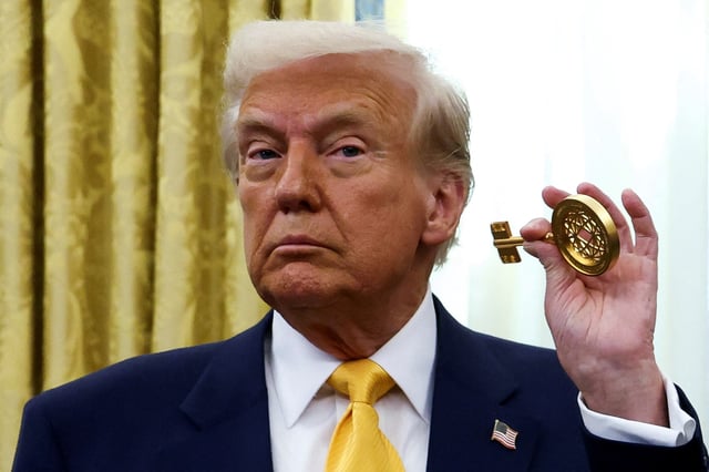 U.S. President Donald Trump holds the key to the FIFA Club World Cup trophy in the Oval Office of the White House in Washington, D.C., U.S., March 7, 2025. REUTERS/Evelyn Hockstein/File Photo