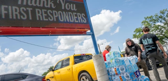 Des volontaires distribuent des bouteilles d'eau alors que les secours poursuivent leurs recherches pour retrouver des survivants après les inondations meurtrières qui ont frappé le texas, à Kerville, le 8 juillet 2025