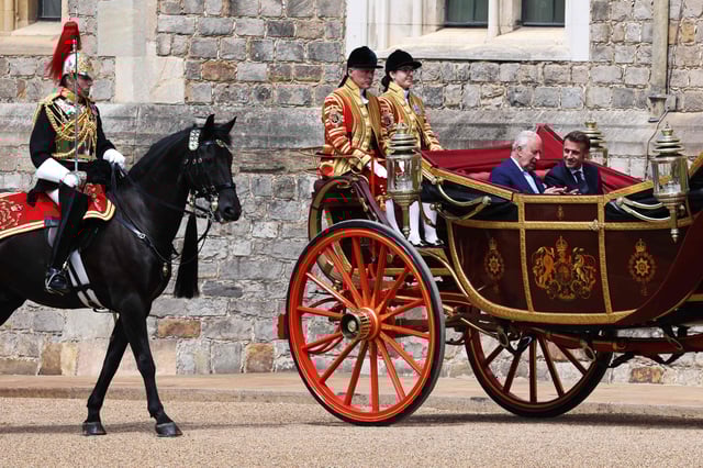 El rey Carlos III de Gran Bretaña y el presidente de Francia, Emmanuel Macron, viajaron en el carruaje estatal Landau de 1902 durante una procesión de carruajes en el Castillo de Windsor, al oeste de Londres, el 8 de julio de 2025, el primer día de una visita de Estado de tres días a Gran Bretaña. (Photo by Ludovic MARIN / POOL / AFP)