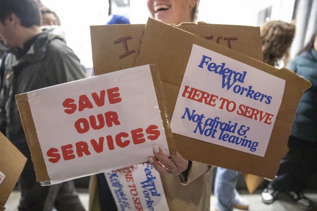 Demonstrators hold signs in rally of support to federal workers and services at risk of being defunded in front of 999 Van Ness Ave. in San Francisco on Feb. 19, 2025.